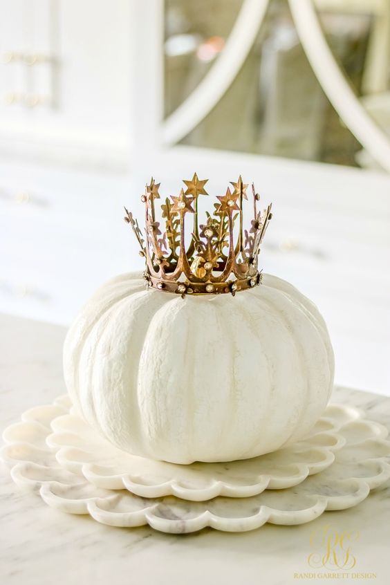 a white pumpkin with a gold crown is an adorable Halloween centerpiece with a strong glam feel