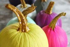 an arrangement of colorful pumpkins with glitter stems for an ultimate glam Halloween party