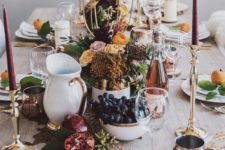 an elegant modern Thanksgiving with tall burgundy candles, copper and gold touches and white porcelain plus blooms