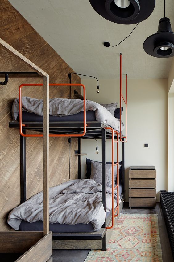 an industrial bunk bed of metal and plywood, with bold orange pipes here and there is a very stylish solution for a boy's room