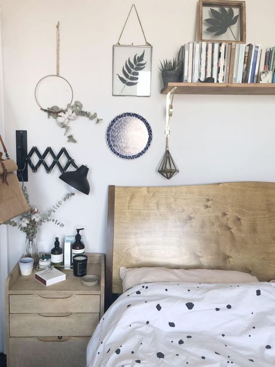 foliage and greenery in frames, hoops and in a vase for a natural feel in the Nordic bedroom