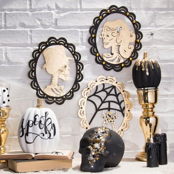 glam Halloween decor with skull portraits, a black and gold dip pumpkin, a bejeweled skull and candles