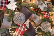 a Christmas tree decorated with lights, beads, faux white blooms, silver grey ornaments and red plaid and semi sheer ribbons is a gorgeous decoration