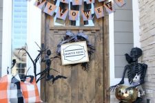 a Halloween porch with white and orange pumpkins, candle lanterns, buntings, a black skeleton and black branches plus a twig wreath