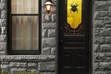 a black door styled with a gold and black decal with a spider is an easy and out of the box idea for Halloween decor