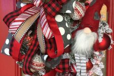 a bold and catchy red and white Christmas wreath with lots of burlap, red, white and grey ribbons, red and white ornaments, a large gnome in a red hat