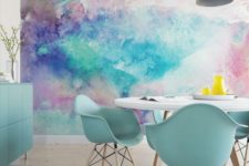 a bright dining space with a colorful watercolor wall mural and mint blue furniture to echo it and make the space cohesive