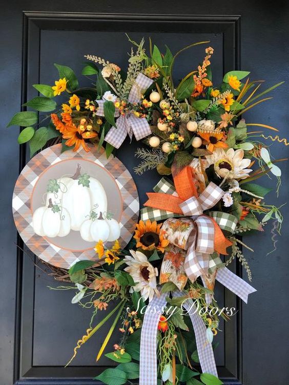 a bright fall posie with faux blooms, greenery, plaid ribbon bows, a plaid sign with pumpkins for Thanksgiving