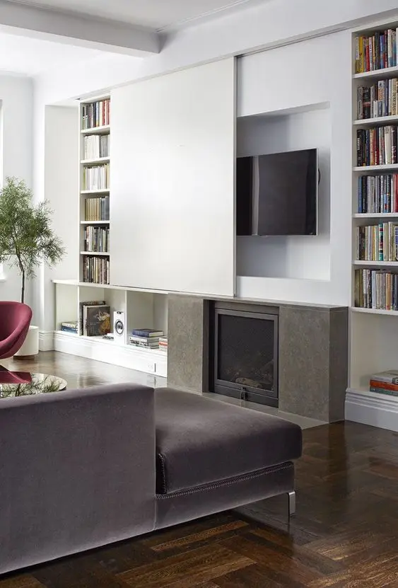 a contemporary living room with a fireplace and a TV over it hidden with a sliding panel is a lovely and cool space