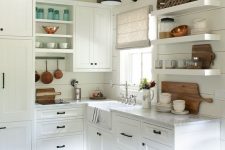 a cute little cottage kitchen with planked walls, open shelves, shaker cabinets, wooden beams and touches of stained wood decor