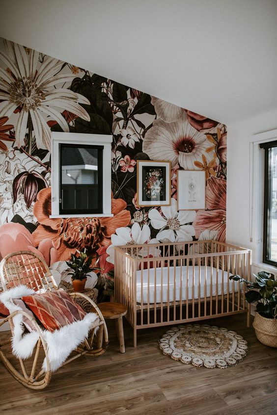 a cute nursery with a bold floral wall mural that gives a tender and romantic feel to the space
