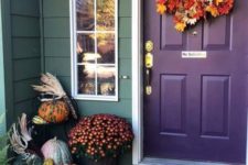 a fall leaf wreath, natural pumpkins, fall blooms in pots and corn husks for decorating for Thanksgiving