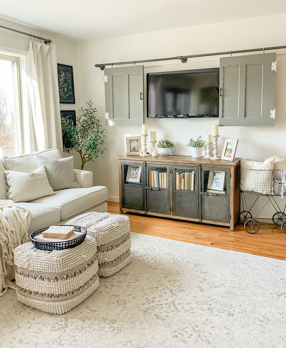 a cozy farmhouse living room where you could hide a tv behind rustic doors