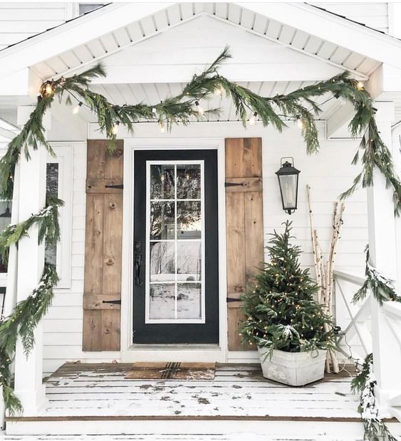 a fir garland with lights, a Christmas tree with lights in a bucket will make your front porch cozy and rustic