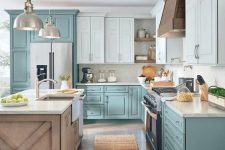 a lovely cottage kitchen with light blue and muted blue cabinets, a stained kitchen island and white stone countertops, pendant lamps