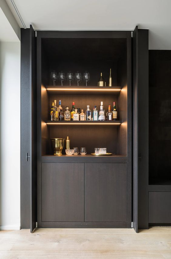 A minimalist dark stained home bar with open shelves with built in lights, a cabinet is a lovely idea for a refined and luxurious space