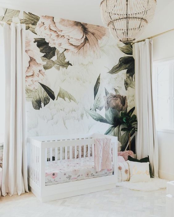 a neutral and airy nursery with a floral wall mural that sets the tone in the space and makes it cooler