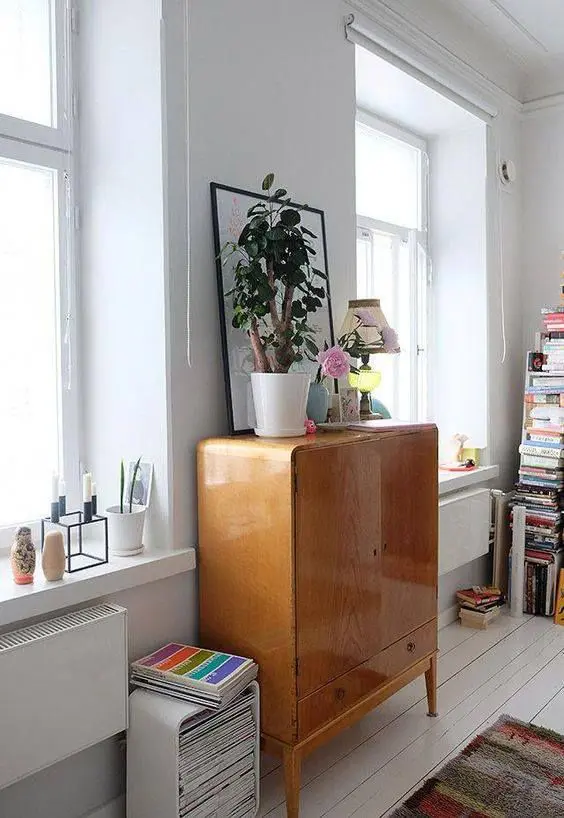 A sleek lacquer storage unit hiding a TV is a smart idea for a mid century modern or Scandinavian interior