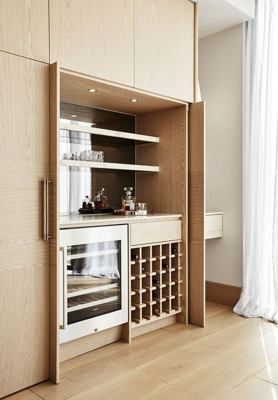 A small modern built in bar with open shelves, a fridge and a wine bottle stand is a stylish idea that can be hidden