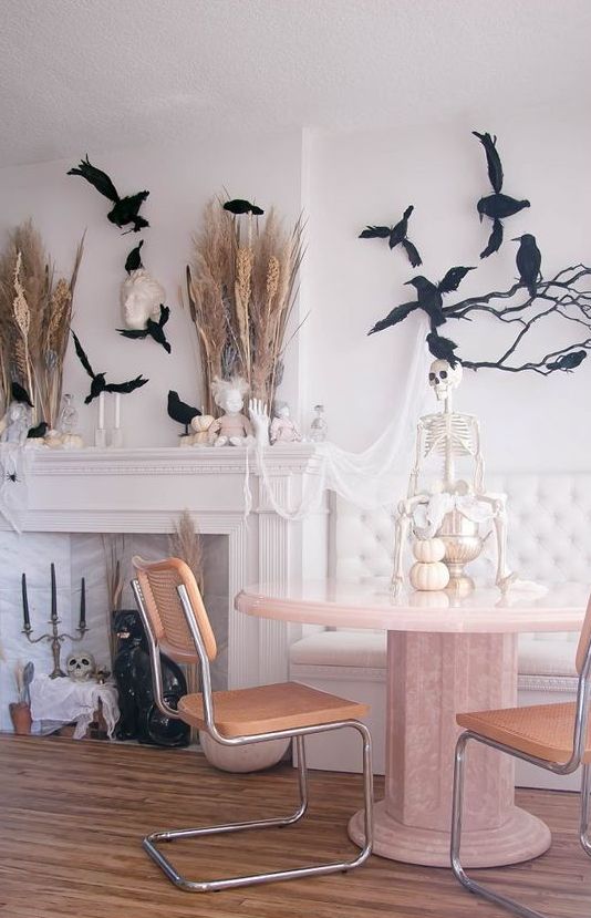 a spooky chic Halloween space wiht wheat and pampas grass, blackbirds, pumpkins and a skeleton is amazing