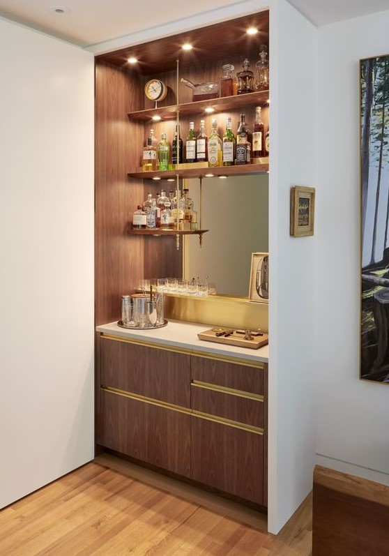 A stylish built in bar with open shelves, a mirror, sleek drawers and lights is a cool and chic idea