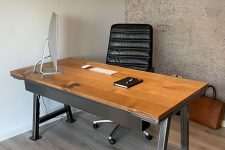 a stylish industrial desk made of wood and metal legs plus a black leather chair for comfortable working