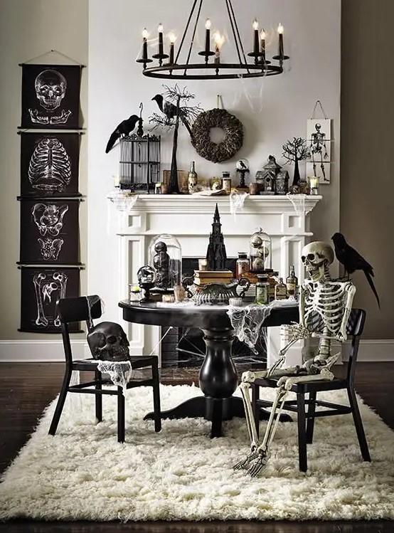 a vintage Halloween space with black posters, skeletons and skulls, blackbirds and wreaths, black furniture and a candle chandelier is wow