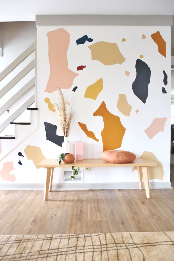 a welcoming entryway with a colorful terrazzo wall mural that brings a fun touch and a bit of color to the space