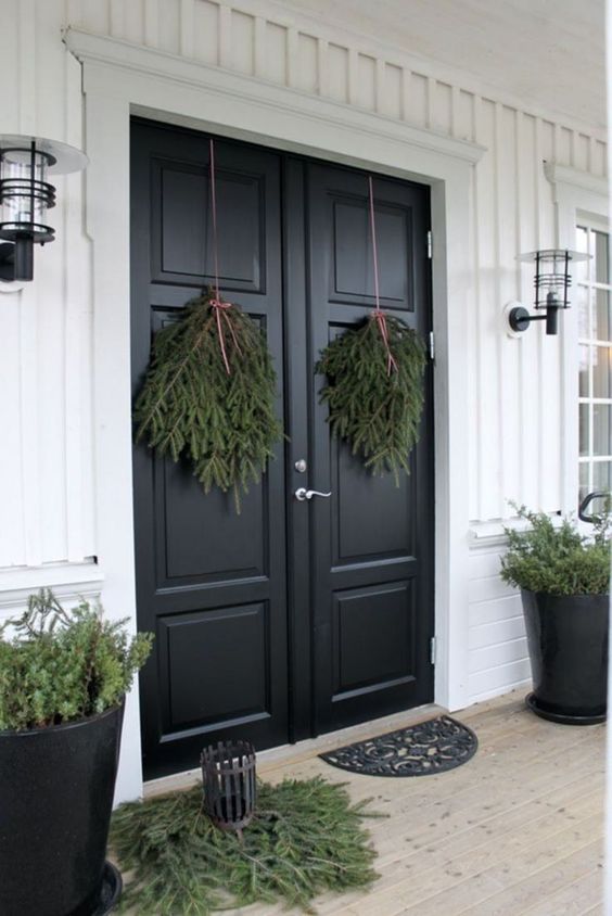 All natural Christmas front door decor with evergreen posies, some evergreens on the floor and in pots