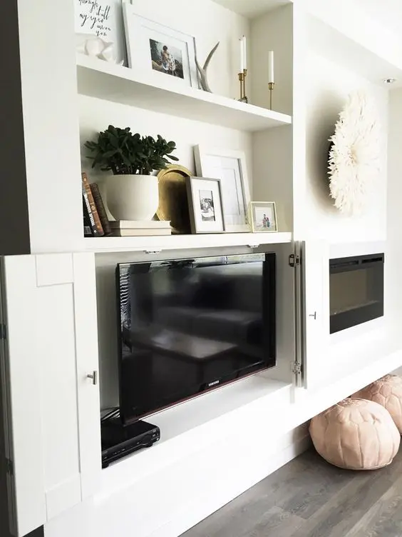 Built in storage units, a fireplace and a TV hidden inside of one of these units are a cool idea for a farmhouse space