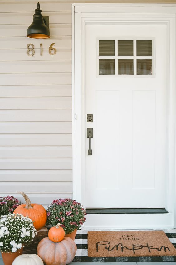fall blooms in pots and some pumpkins plus a mat will make your porch Thanksgiving-ready