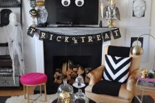 glam Halloween decor with a black banner, spiders, bats, gold skulls and a hot pink stool