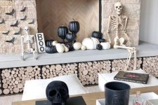 modern Halloween styling with a couple of skeletons and skulls, black and white pumpkins, paper bats and a sign