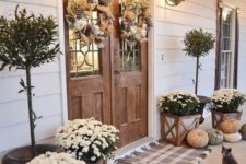 neutral pumpkins, white blooms in pots, wreaths of burlap, pinecones and white pumpkins for Thanksgiving