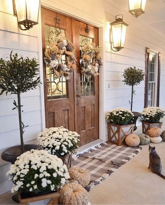 neutral pumpkins, white blooms in pots, wreaths of burlap, pinecones and white pumpkins for Thanksgiving