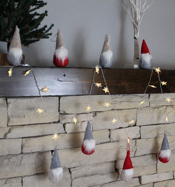 Pretty Christmas decor   red and grey gnomes n hats, a star shaped light garland are all you need for a cool Christmas mantel