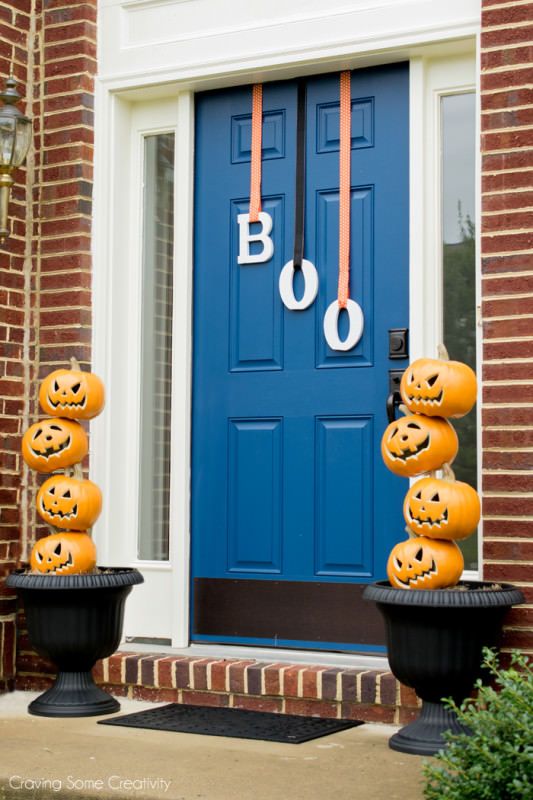 Stacked jack o lanterns and letters hanging on the door instead of a usual Halloween wreath are a great idea to go for