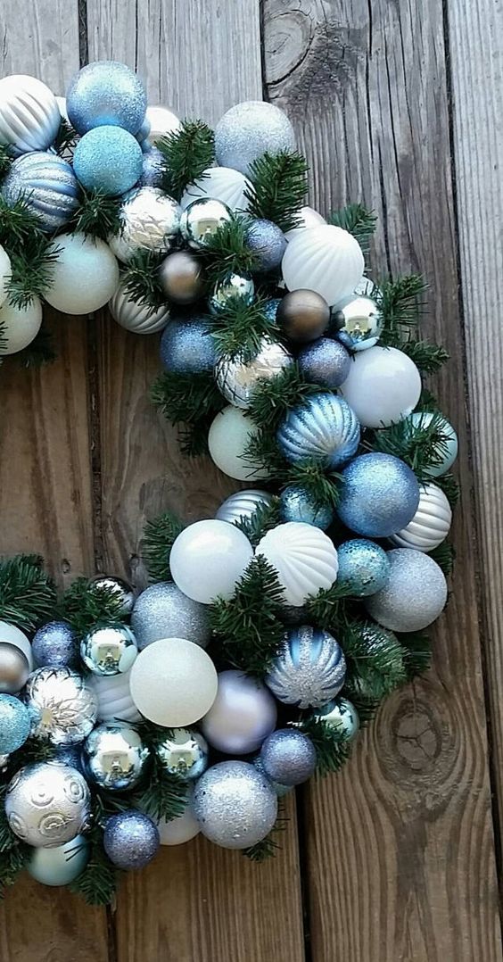 a Christmas wreath decorated with blue white, silver and chocolate ornaments looks very elegant and very chic