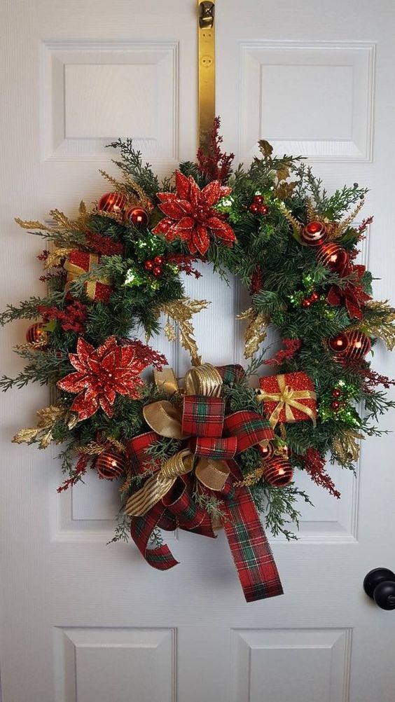 a beautiful Christmas wreath of evergreens, with poinsettia, gift boxes and ribbon bows plus ornaments