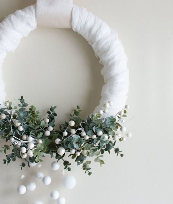 a beautiful winter wreath in white, with lush greenery, snowballs and beads is a lovely option for Christmas front door decor