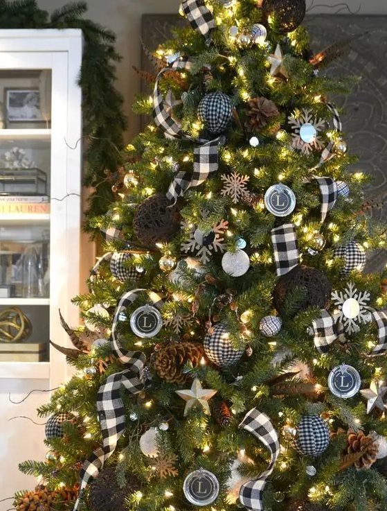 a black and white Christmas tree with pinecones, lights and buffalo check ornaments and garlands