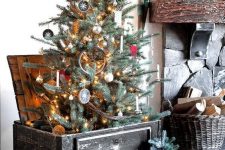 a black wooden box with a Christmas tree, a basket with firewood and a mini tree in a crate for a rustic feel