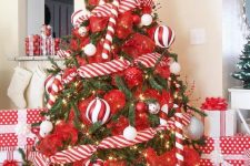 a colorful Christmas tree decorated with lights, red and red and white ribbons, overiszed candy canes and ornaments is ultimate fun