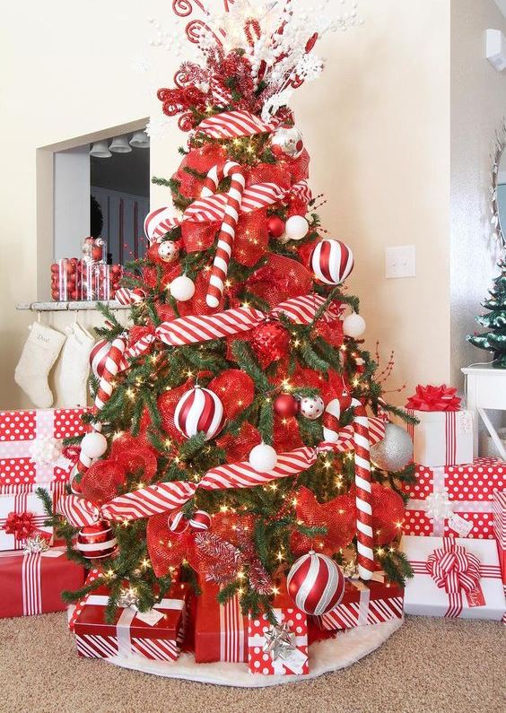 a colorful Christmas tree decorated with lights, red and red and white ribbons, overiszed candy canes and ornaments is ultimate fun