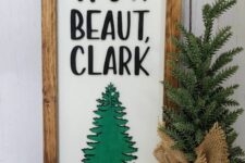 a cool Christmas sign with letters, a green tree and a stained wooden frame is a cool farmhouse or rustic decor idea