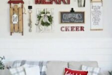 a cozy gallery wall with marquee lights, signs, a wreath, a lantern, a sleigh and some greenery