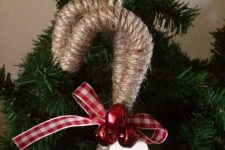 a cozy rustic Christmas ornament – a twine wrapped candy cane with red bells and a plaid bow is a lovely idea
