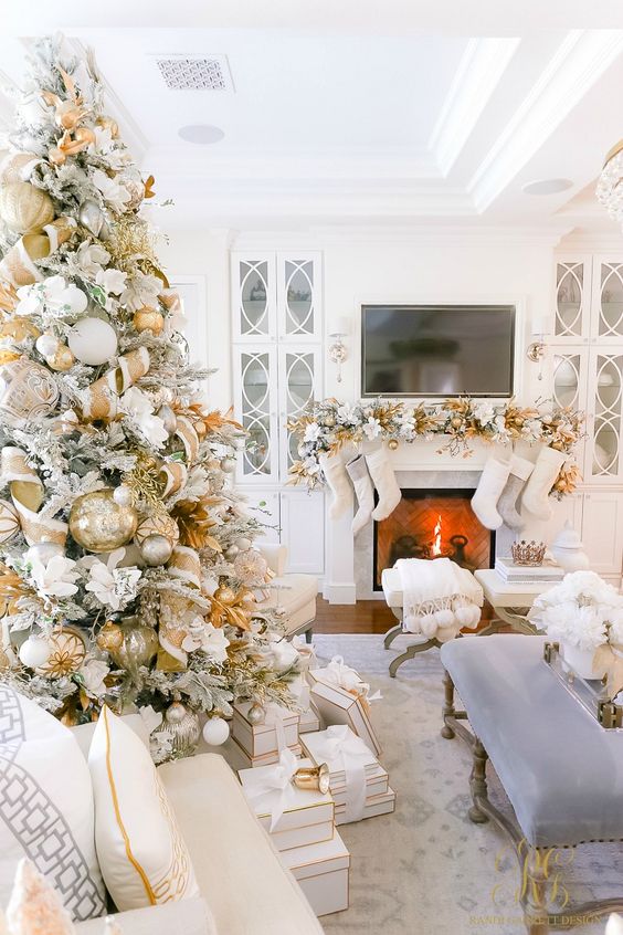 a glam and shiny Christmas tree decorated with white faux blooms, gold and white ribbons, ornaments and leaves