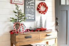 a gorgeous gallery wall for holidays with a couple of wreaths, signs and a fake deer head for your entryway
