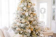 a jaw-dropping Christmas tree with oversized gold, silver and white ornaments, gold and white ribbons and white fabric blooms